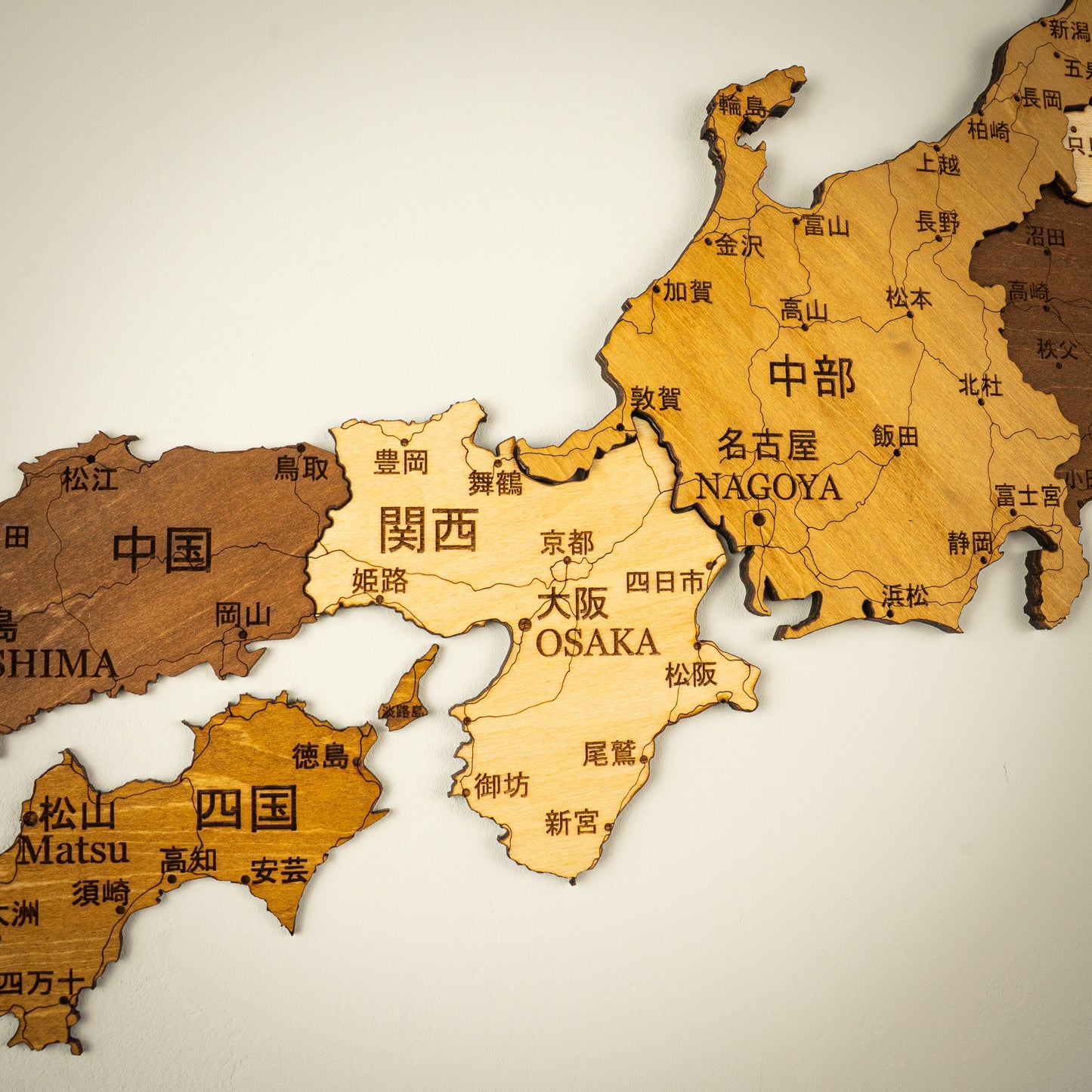 Wooden map of Japan with cities labeled on a beige background