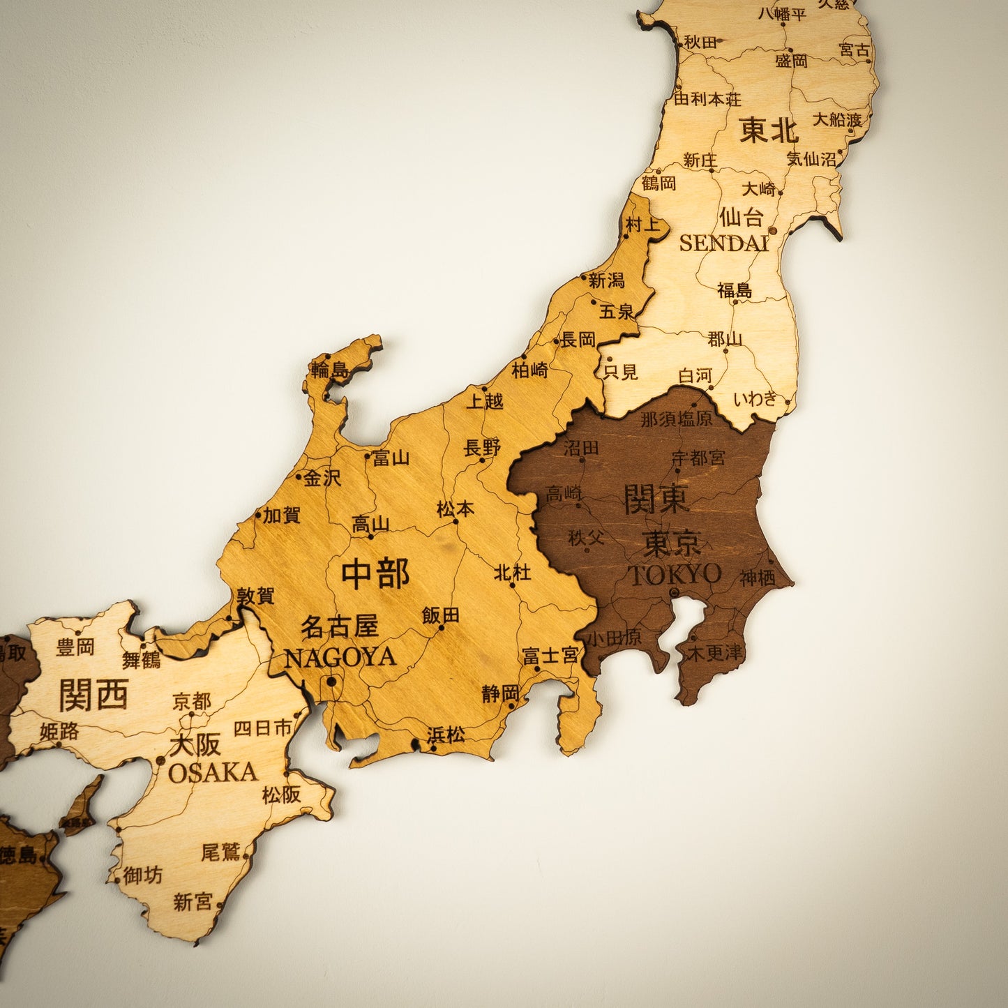 Wooden map of Japan with major cities labeled on a beige background