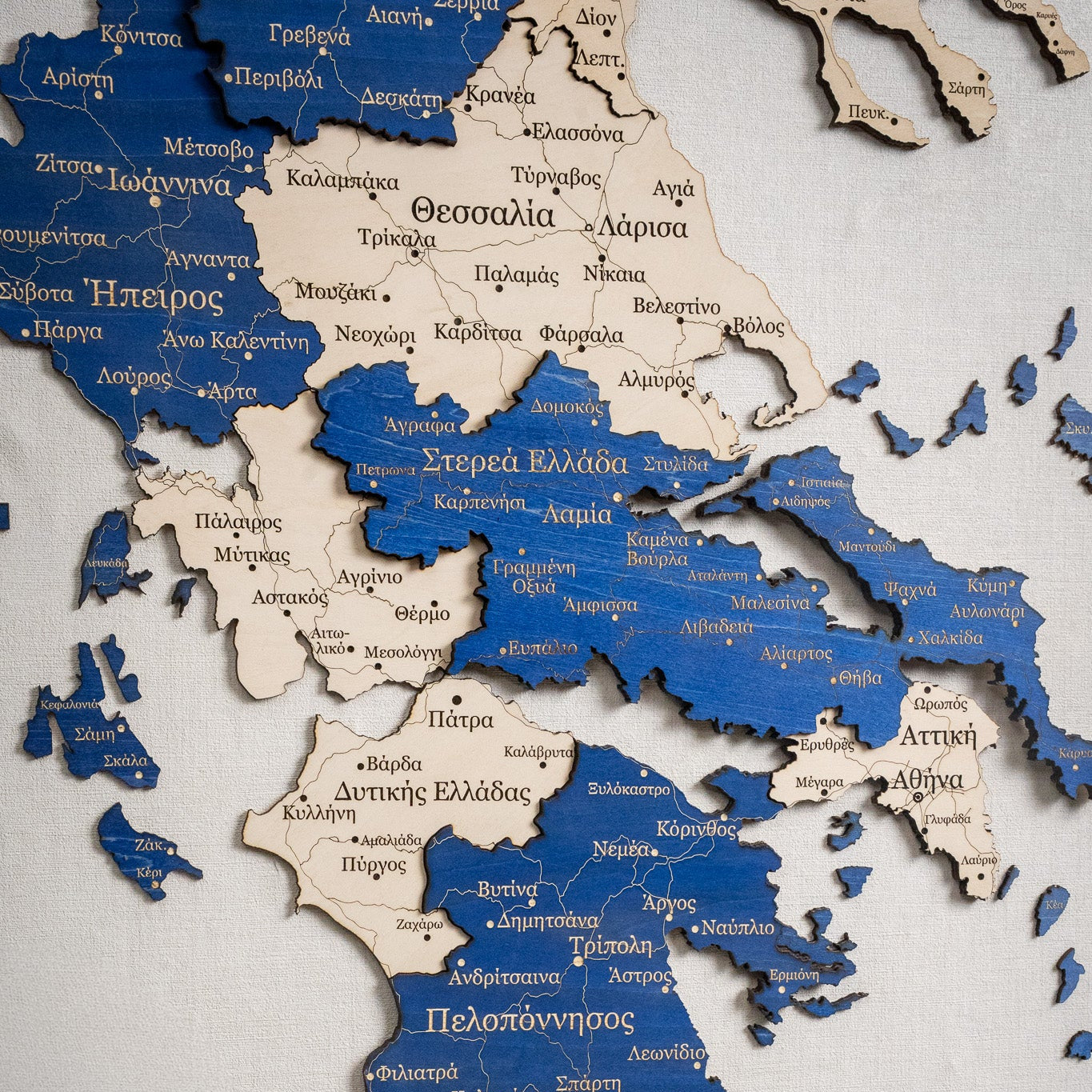 Wooden map of Greece with Greek text on a white background