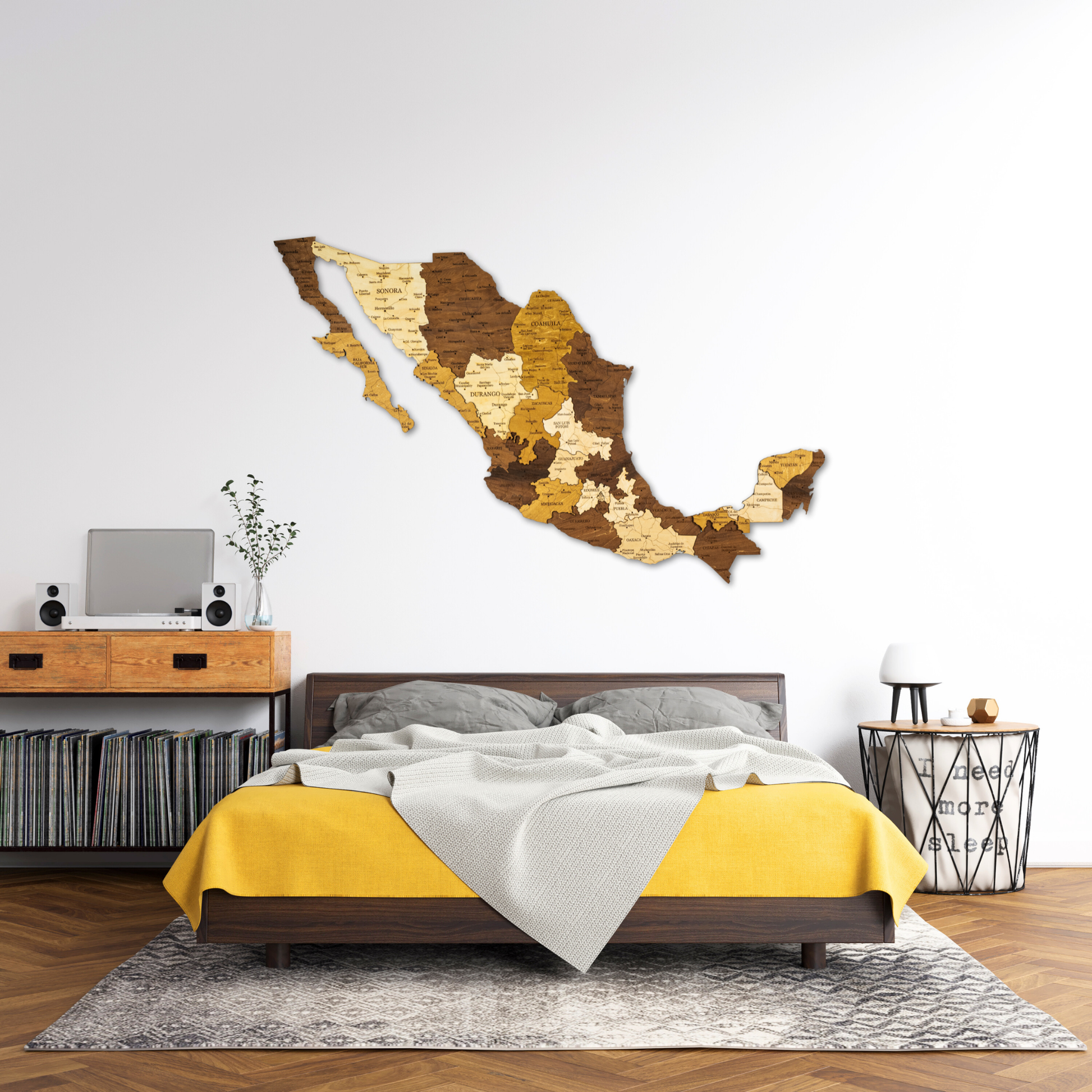 Bedroom with a wooden wall decoration shaped like Mexico, yellow bedding, and a wooden desk.