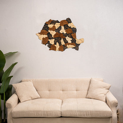 Wooden wall art of Romania map on a light gray wall above a beige sofa.