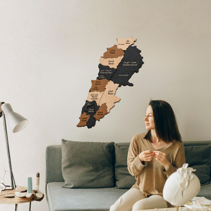 Woman sitting on a couch in a living room with a wooden map of lebanon on the wall.
