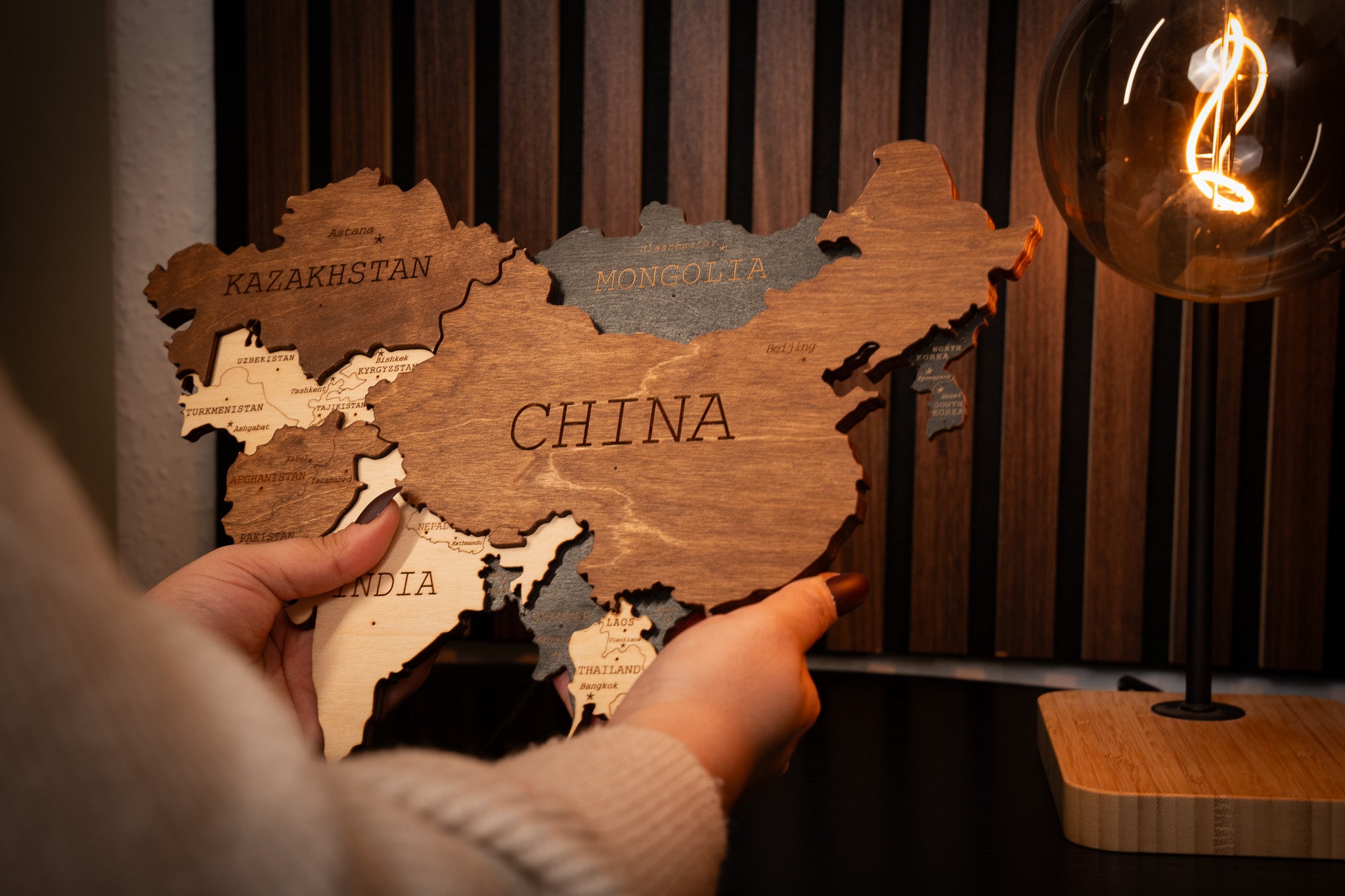 Wooden map of China with a decorative light bulb on a wooden background