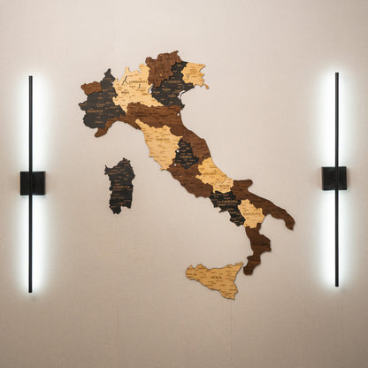 Wooden map of Italy on a wall with two lights on either side.