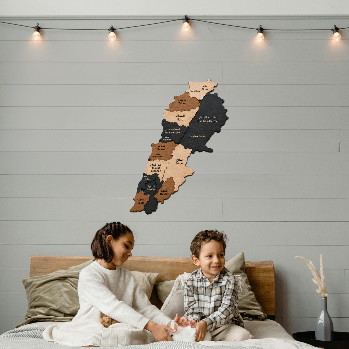 Wooden map of lebanon in 3D on the wall above a bed